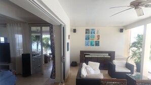 A living room with a sofa, a TV, and a dining area with a table. - Spacious Indoor/Outdoor living. Private pool. Amazing ocean views (Half Moon Bay)