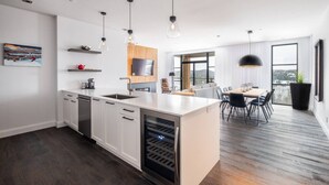 A modern kitchen with a central island, built-in appliances, and pendant lighting. - Tremblant Prestige - Horizon 1-104 (Mont-Tremblant)