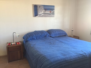 A bedroom with a bed, two bedside tables, a lamp on each table, and a painting on the wall. - Great Specials! Pet Friendly! Spectacular Views! 4 Bedrooms/4 Baths, Sleeps 8! (Puerto Peñasco)