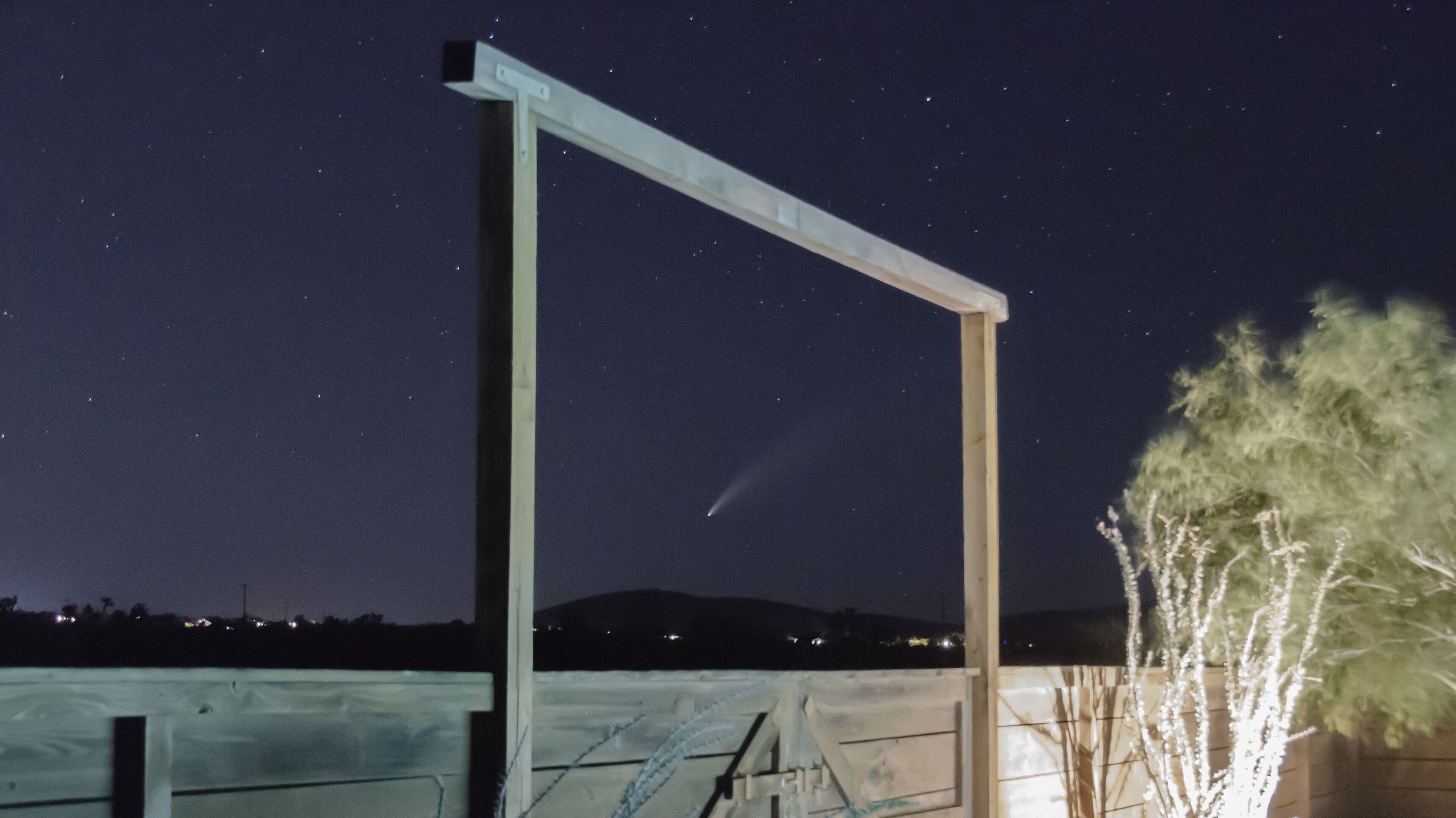A metal structure with a horizontal beam and a vertical support against a night sky with stars.