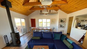 Una sala de estar moderna con un sofá seccional, una chimenea y un comedor.