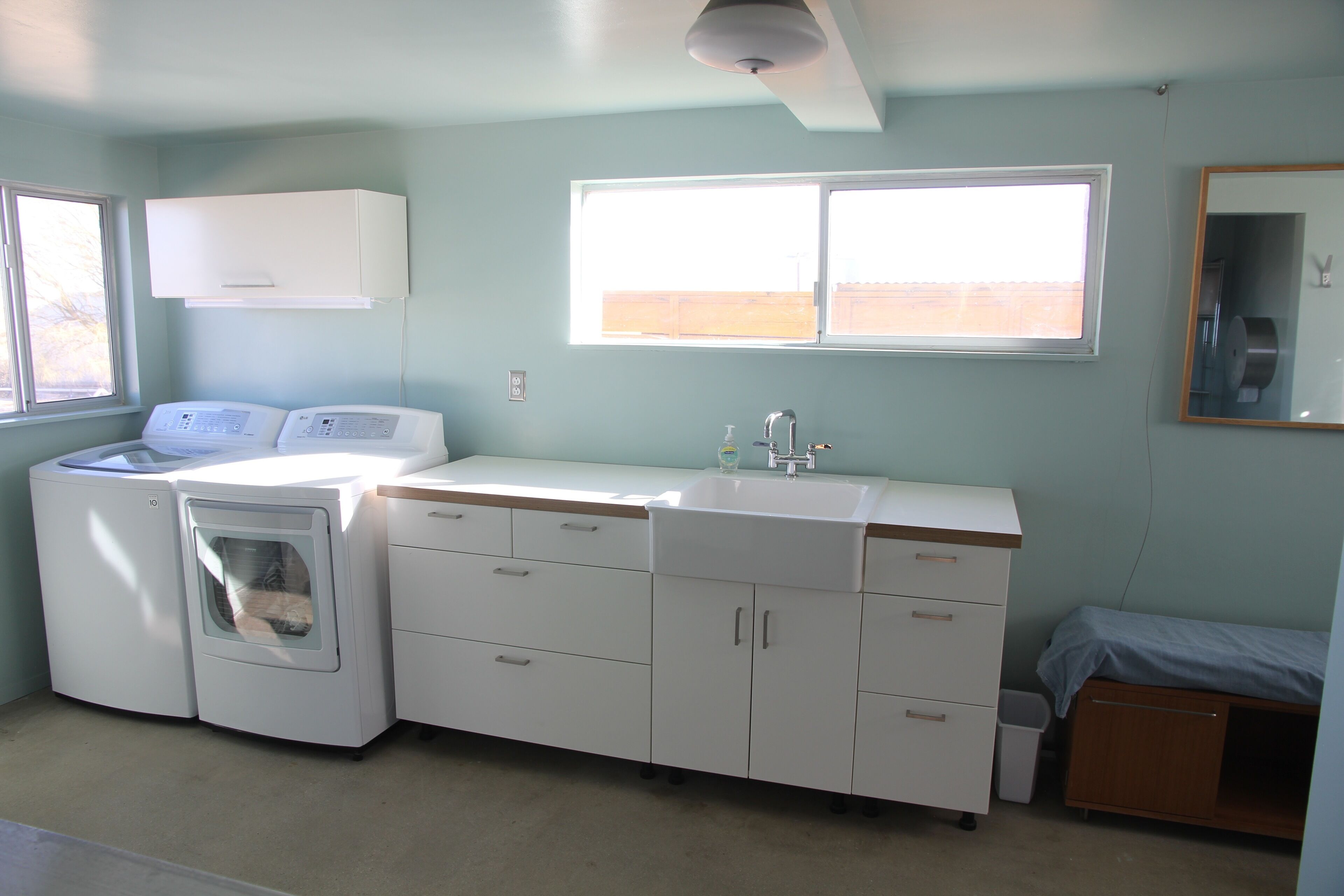 A laundry room with a washing machine, dryer, and a sink.