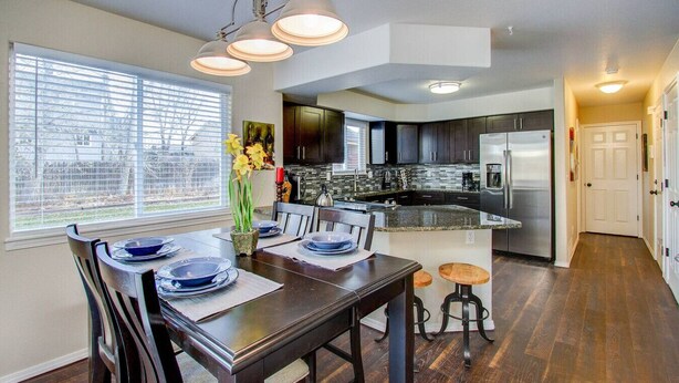 A modern kitchen with dark cabinets, stainless steel appliances, and a granite countertop. - Spacious 4BR w/ EV Charger & Hot Tub (Colorado Springs)