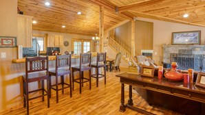 Un intérieur en bois comprenant un coin repas, une cheminée et un escalier.