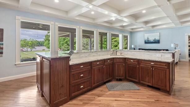 A spacious kitchen with a large island, wooden cabinets, and a view of the outdoors. - Lakefront/8 Acres/Views/Families/Pool Table/Fire Pit/Kayaks/SUP/Quiet/HotTub (Greensboro)