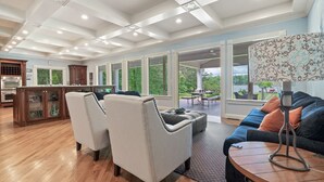 A spacious living area with a kitchen, large windows, and a view of the outdoors. - Lakefront/8 Acres/Views/Families/Pool Table/Fire Pit/Kayaks/SUP/Quiet/HotTub (Greensboro)