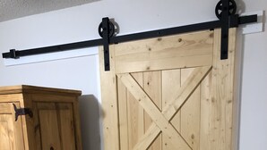 Ein Schrank aus Holz mit Schubladen und einer Schiebetür im Bauernhausstil.