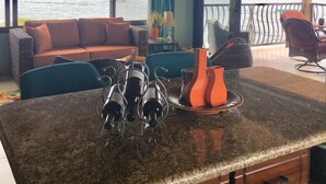 A spacious living area with a large window overlooking the sea, a ceiling fan, and a dining area with a table and chairs. -  Location with spectacular views and six minute walk to the beach!!!  (Roatan)