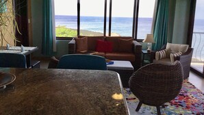 A room with a large window overlooking the ocean, a sofa, a chair, and a dining table. -  Location with spectacular views and six minute walk to the beach!!!  (Roatan)
