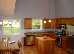 Enjoy cooking in this well-equipped kitchen with a central island, oven, and dining area.