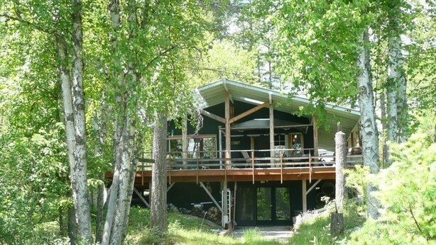 A cabin with a wooden deck, surrounded by trees. - King's Cabin, just 2 miles from the Park entrance in West Glacier! (West Glacier)