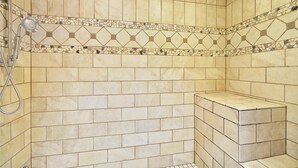 Zona de ducha con paredes de azulejos y ducha.