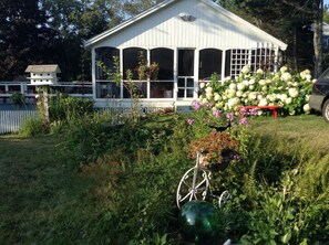 Escape to a serene garden oasis with a charming gazebo surrounded by lush greenery and vibrant blooms.