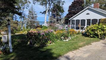 A cottage with a garden and a view of the sea.