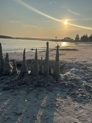 Unique rock formations stand against the serene beach backdrop.