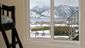 A window with a view of snow-covered mountains and a lake. - Expansive views, hot tub, & kid friendly! Perfect for multiple families! (Manson)
