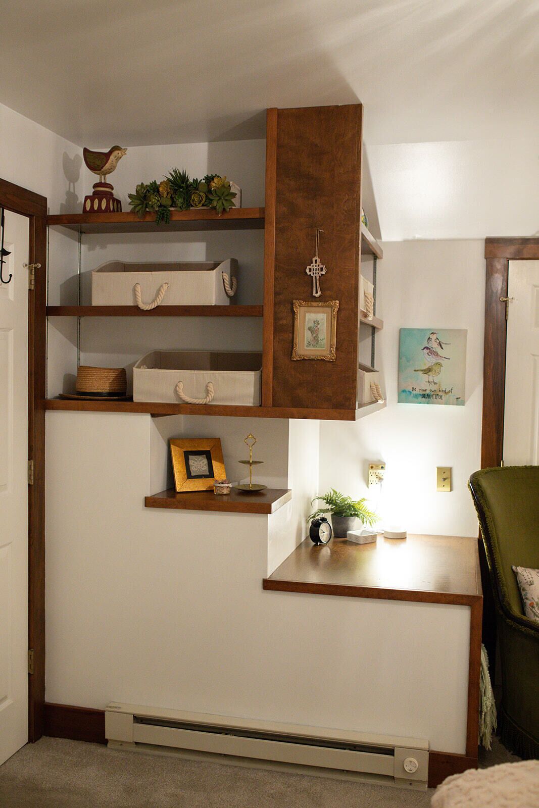 Una stanza con un mobile a scaffali in legno, una scrivania, un termosifone e un quadro appeso al muro.