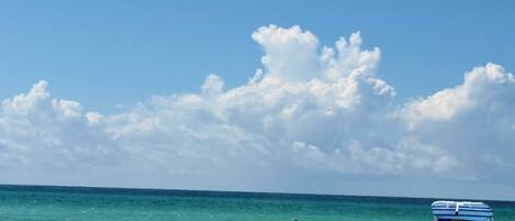 A beach scene with a clear sky, a person swimming, and a beach chair labeled 'Alvin's Island'.