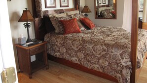 A four-poster bed with a patterned bedspread, two bedside tables with lamps, and framed pictures on the wall. -  Hidden Gem!  Exceptional 1 bed/1bath ocean & beachfront Kihei condo (Kihei)