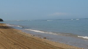 A sandy beach with visible tire tracks and a calm sea. -  Hidden Gem!  Exceptional 1 bed/1bath ocean & beachfront Kihei condo (Kihei)