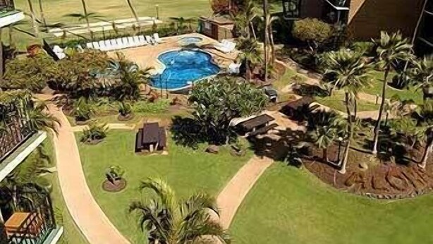A resort with a pool, palm trees, and a view of the ocean. -  Hidden Gem!  Exceptional 1 bed/1bath ocean & beachfront Kihei condo (Kihei)
