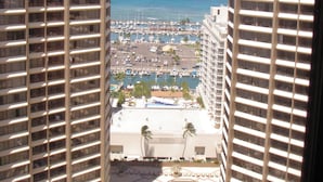 Een hoog hotel met uitzicht op een jachthaven en de oceaan.