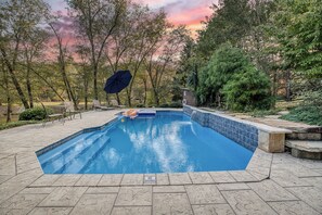 A swimming pool with a 'NO DIVING' sign, surrounded by trees and a sunset sky.