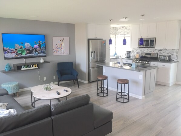 A modern kitchen with a central island, stainless steel appliances, and pendant lighting.