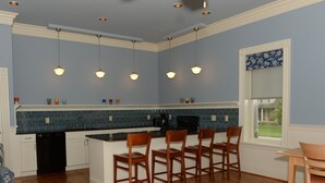 Una cocina con una isla central, sillas de madera y una mesa de comedor.