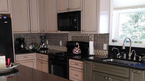 Una cocina moderna con una isla central, encimeras oscuras y armarios de madera.