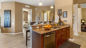 A kitchen with granite countertops, stainless steel appliances, and a built-in dishwasher. - Top Floor 2000 sq ft Lakefront Corner Condo | Walk to Epic (Orlando)