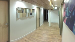 A hallway with wooden flooring, a wooden door, and a wall-mounted mirror. - Up to 50% off select nights! Huge Loft, Foosball Table, Professionally Cleaned!! (Nashville)