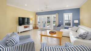 A living room with a TV, sofas, and a table. - Waterfront luxury Villa (29) with sunset views and boat slip (Marathon)