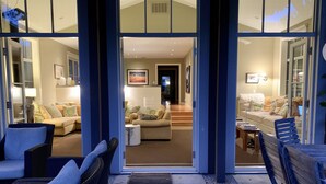 A modern interior with a living area, a dining area, and a kitchen visible through glass doors. - Spa-Like Paradise Walking Distance To Wineries,  Shops, No Final Cleaning Fee (St. Helena)