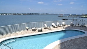 A pool with lounge chairs and a view of the water. - 360° View of Water - The Entire 18th Floor - 4 Bedroom Penthouse (Gulf Shores)
