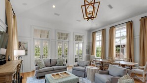 A spacious living room with a large sofa set, a coffee table, and a dining area with a table and chairs. - PRIVATE BEACH ACCESS-Newly Refurbished-Pool-4 Bikes-Close to Town Center/Beach (Panama City Beach)