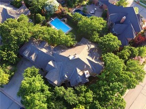 A residential area with multiple houses, a swimming pool, and lush greenery. - Spacious, newly remodeled home near I-35 in Edmond (Edmond)