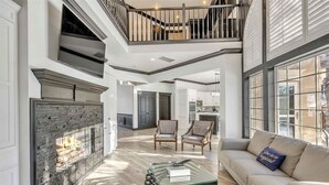 A spacious living area with a fireplace, a staircase, and a view of the outside. - Spacious, newly remodeled home near I-35 in Edmond (Edmond)