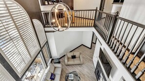 A multi-level interior with a staircase, a chandelier, and a sofa area. - Spacious, newly remodeled home near I-35 in Edmond (Edmond)