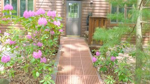A wooden cabin with a porch, a door, and a mailbox. - Spa Cabin: Lakefront w Private Sauna & Hot Tub, Kayaks, Dock, 5 Star Clean Rated (Oakland)