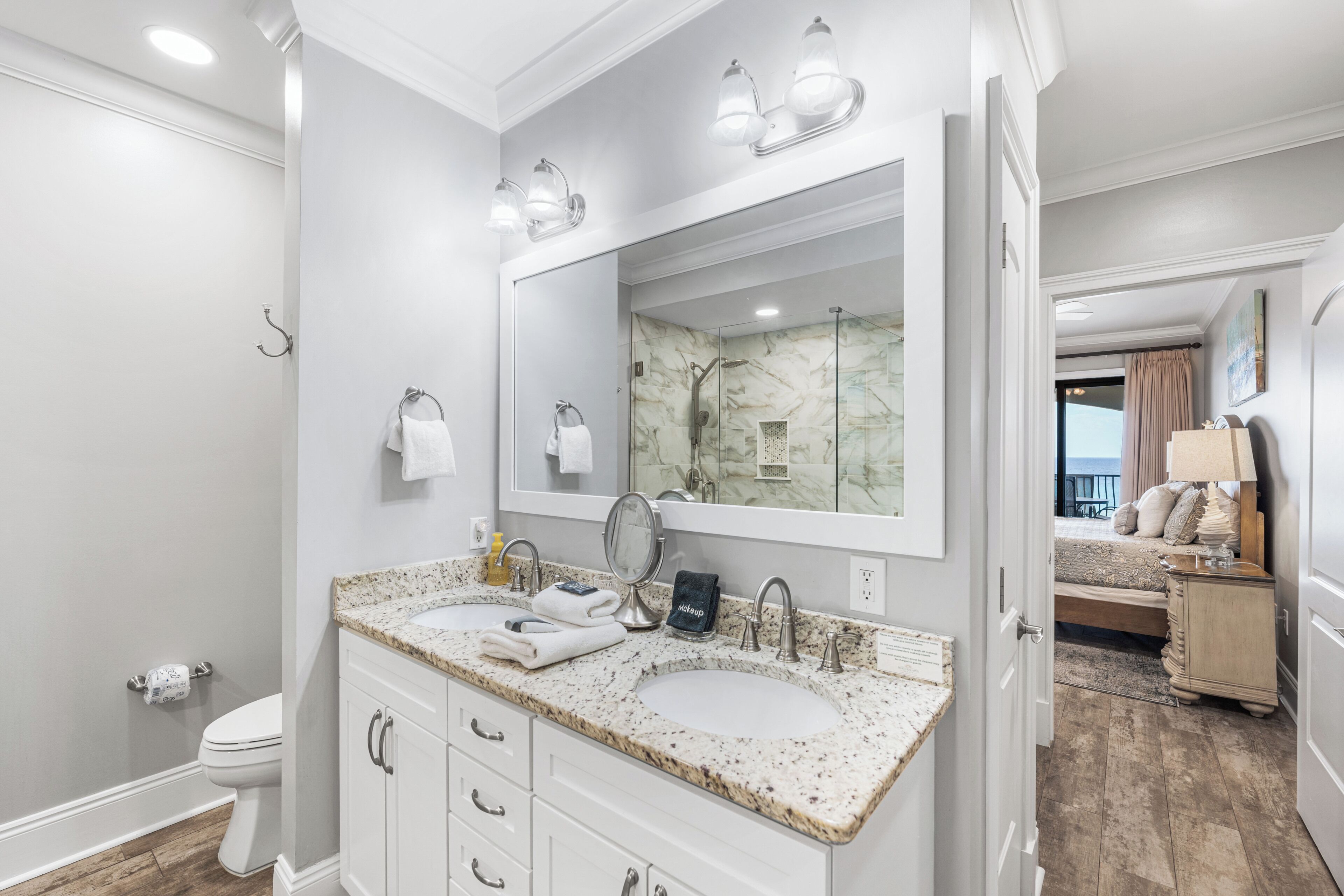 Une salle de bain avec deux lavabos, un grand miroir et une douche.