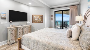 Una camera da letto con un letto, una televisione, una cassettiera e un balcone con vista.