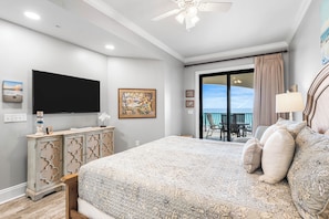 Une chambre avec un lit, une télévision, une commode et un balcon offrant une vue.