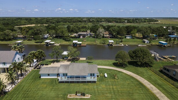 Una casa grande con un jardín amplio, un muelle y vista al lago.
