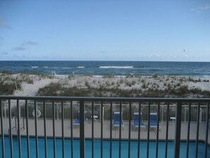 A poolside view with a beach in the background. - Elevated First Floor Beachfront w/ Beautiful Balcony Views (Gulf Shores)