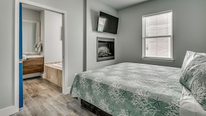 Un dormitorio con cama, televisión, chimenea y ventana.