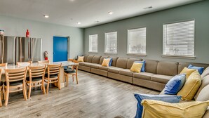 Una sala de estar moderna con un sofá modular, una mesa de comedor y sillas.