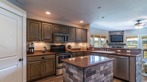 A modern kitchen with wooden cabinets, stainless steel appliances, and a large island. -  Luxury Riverwalk Townhome Overlooking The River, Hot Tub, A/C, Close To Town. (Pagosa Springs)