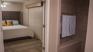 Ein Hotelzimmer mit Bett, begehbarem Kleiderschrank und Duschbereich.