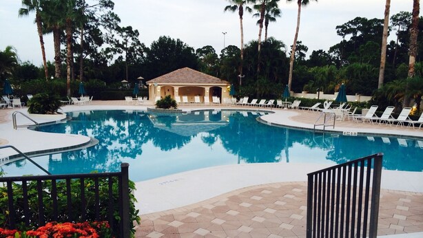A swimming pool with lounge chairs and a gazebo.